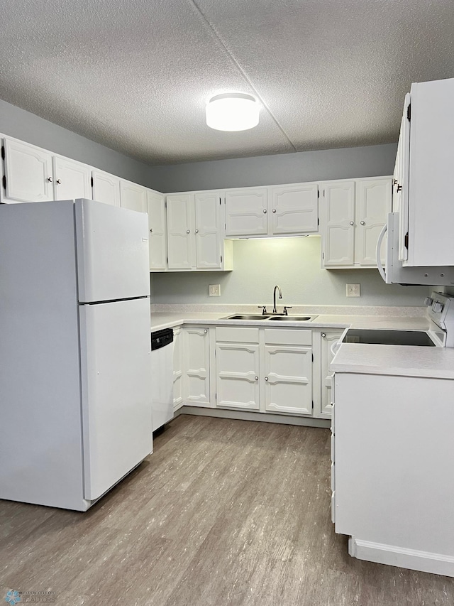 kitchen featuring sink, white appliances, white cabinetry, and light wood-type flooring