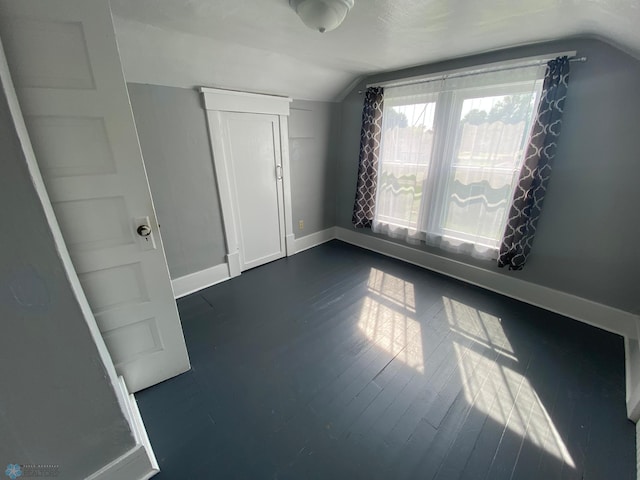 bonus room with dark hardwood / wood-style flooring and lofted ceiling