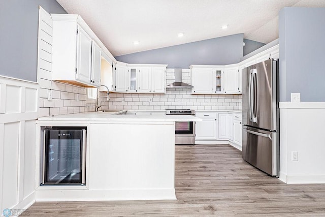 kitchen featuring stainless steel fridge, electric range, light hardwood / wood-style flooring, and lofted ceiling