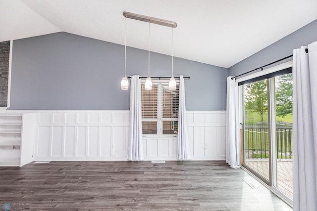 unfurnished dining area featuring hardwood / wood-style floors and lofted ceiling