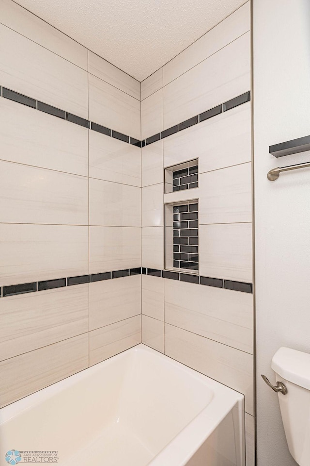 bathroom featuring tiled shower / bath and toilet