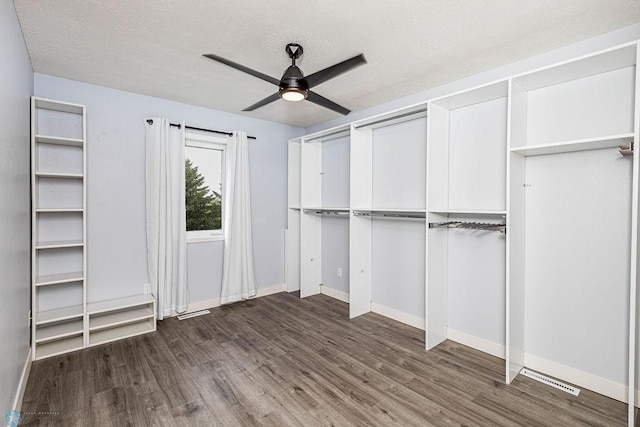 interior space featuring dark hardwood / wood-style flooring, a textured ceiling, and ceiling fan