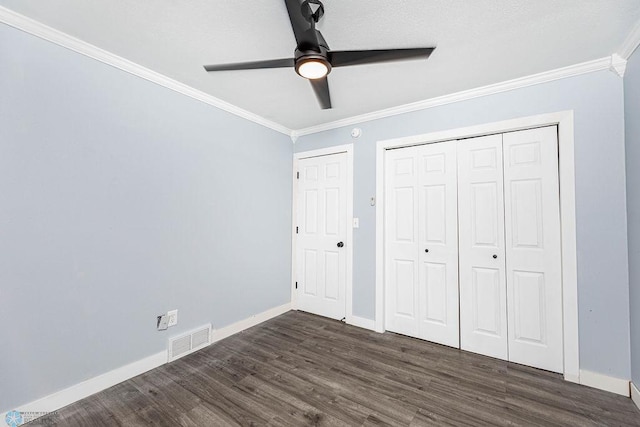 unfurnished bedroom with ceiling fan, dark wood-type flooring, and ornamental molding