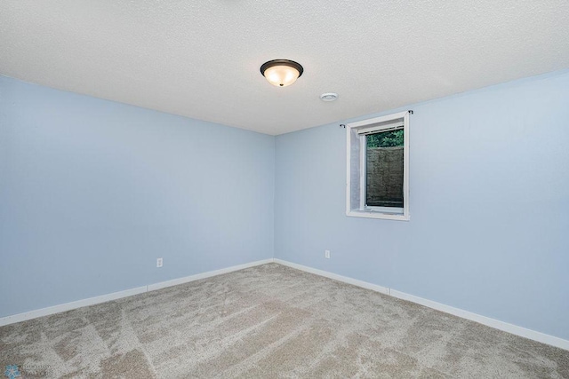 spare room with carpet and a textured ceiling