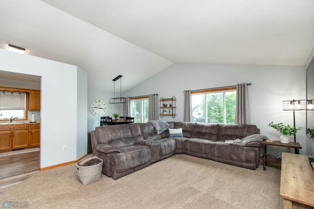 living room featuring sink, lofted ceiling, and light wood-type flooring