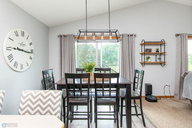 dining area featuring lofted ceiling and wood-type flooring