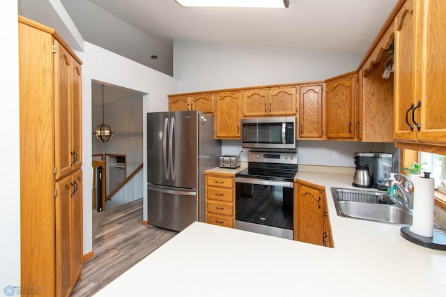 kitchen with stainless steel appliances, light hardwood / wood-style flooring, sink, lofted ceiling, and kitchen peninsula