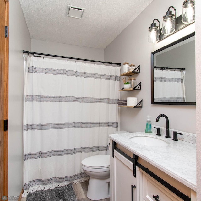 bathroom featuring a textured ceiling, toilet, vanity, and hardwood / wood-style flooring