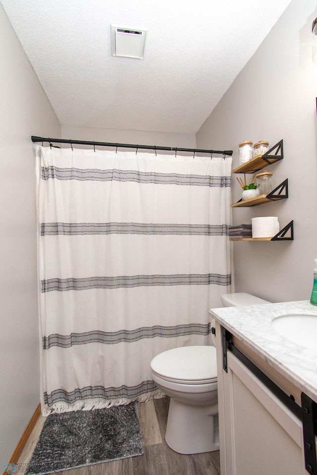 bathroom with hardwood / wood-style floors, toilet, a textured ceiling, and vanity