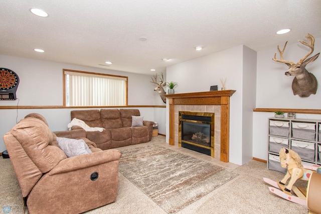 living room with a textured ceiling, light colored carpet, and a tile fireplace