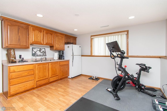 exercise area featuring sink and light hardwood / wood-style floors