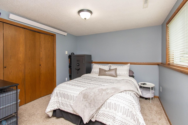 carpeted bedroom featuring a closet and a textured ceiling