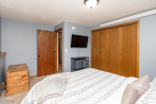 bedroom with a textured ceiling, a closet, and light carpet