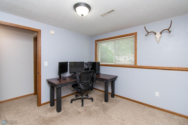 carpeted office space featuring a textured ceiling