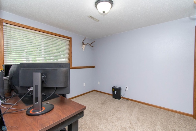 carpeted office featuring a textured ceiling