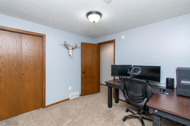 home office with a textured ceiling and light colored carpet