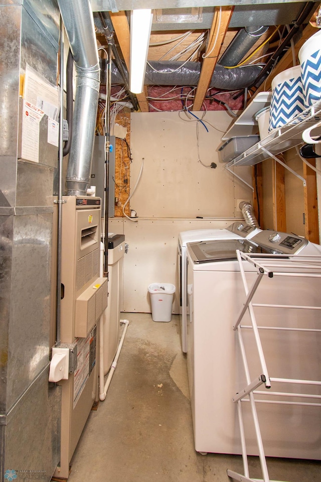 basement featuring washing machine and clothes dryer and heating unit