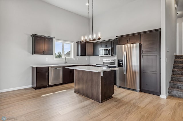 kitchen featuring refrigerator, light hardwood / wood-style floors, dishwasher, and a high ceiling