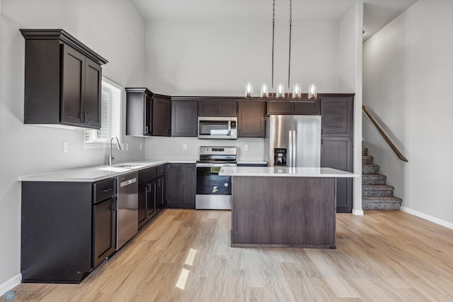 kitchen with sink, a center island, appliances with stainless steel finishes, light hardwood / wood-style flooring, and dark brown cabinets