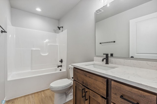 full bathroom featuring shower / tub combination, vanity, hardwood / wood-style floors, and toilet