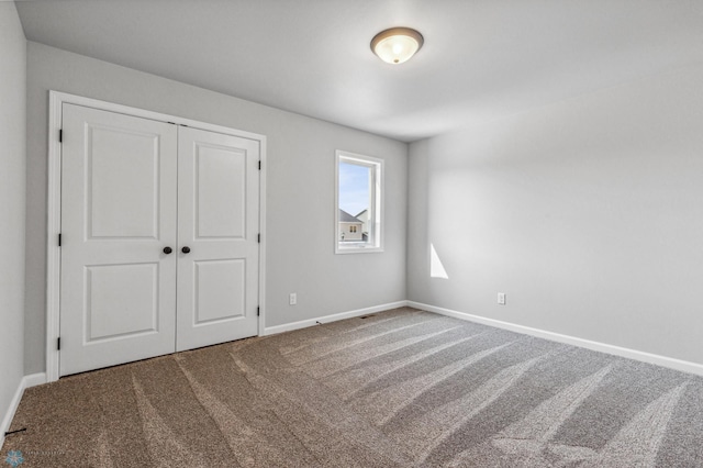 unfurnished bedroom with a closet and carpet flooring