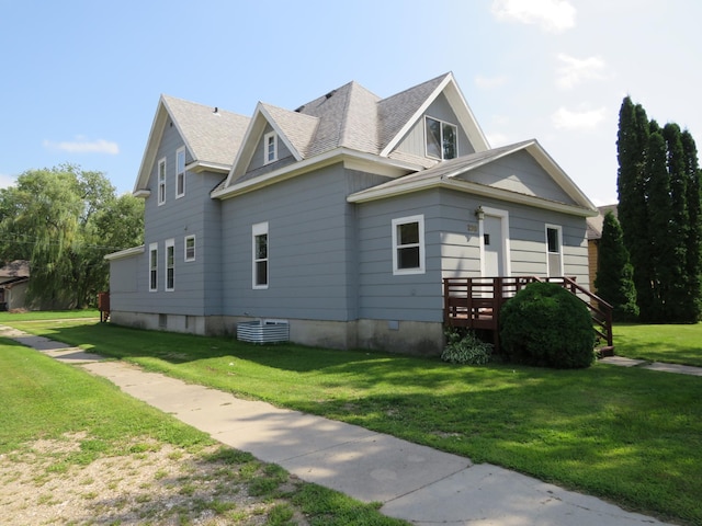 view of side of property with a wooden deck, central AC unit, and a lawn