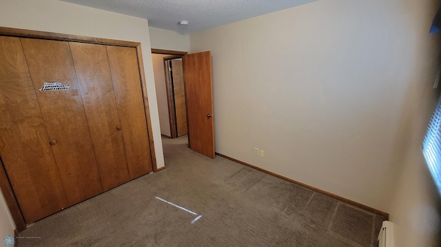 unfurnished bedroom with a closet, a baseboard radiator, light colored carpet, and a textured ceiling