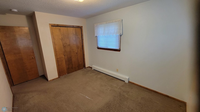 unfurnished bedroom with a textured ceiling, a closet, baseboard heating, and light carpet