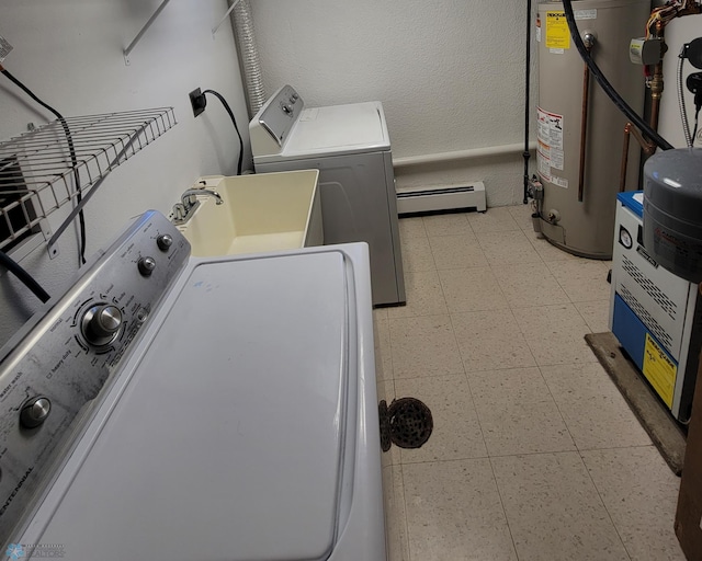 washroom with sink, water heater, a baseboard radiator, light tile patterned floors, and independent washer and dryer