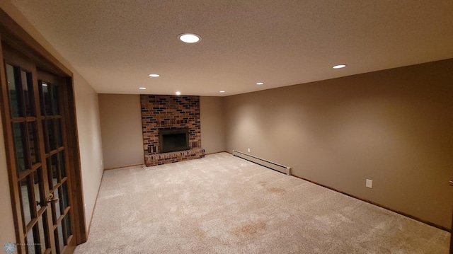 unfurnished living room with a brick fireplace, baseboard heating, a textured ceiling, carpet flooring, and brick wall