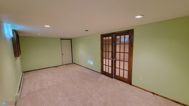 carpeted empty room with a baseboard radiator and french doors