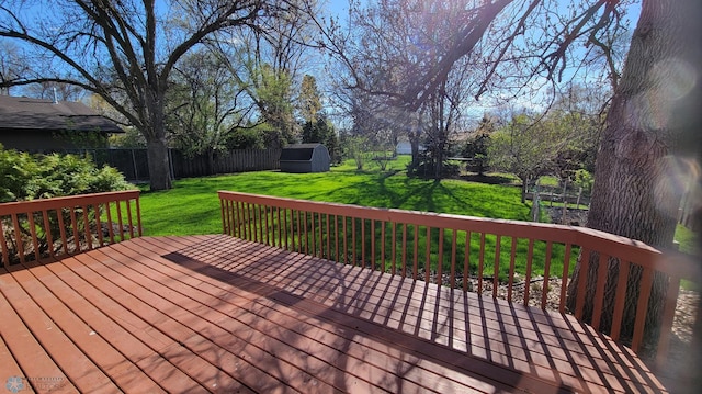 deck featuring a storage shed and a yard