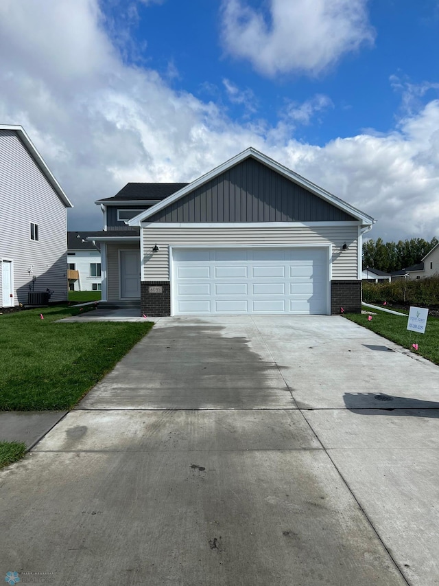 view of front facade with a front lawn, central AC unit, and a garage