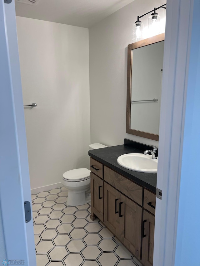 bathroom featuring tile patterned floors, toilet, and vanity