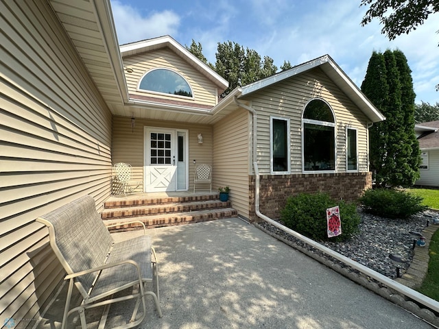 view of exterior entry with a patio area