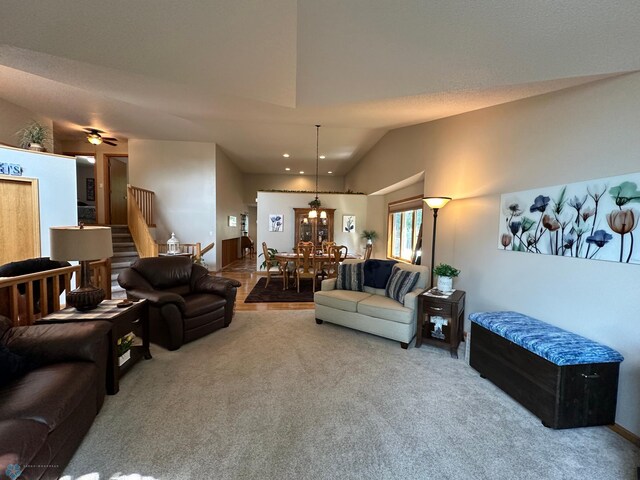 carpeted living room featuring vaulted ceiling and ceiling fan