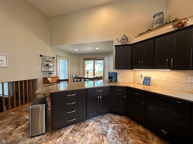 kitchen with light tile patterned floors, light stone counters, decorative backsplash, and kitchen peninsula