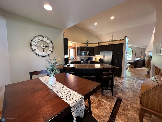 dining room featuring high vaulted ceiling and dark tile patterned floors