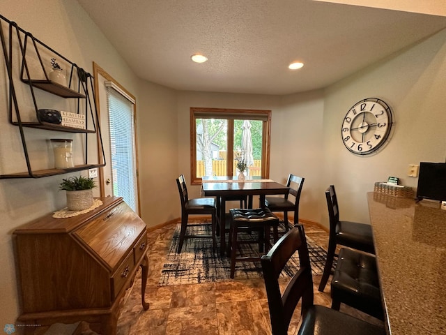 tiled dining space with a textured ceiling