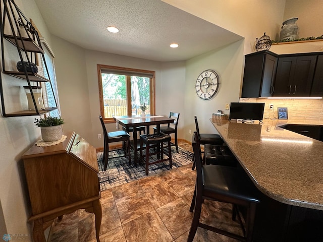 tiled dining room with a textured ceiling