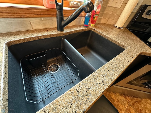 exterior details featuring light stone counters and sink