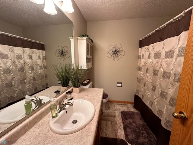 bathroom featuring a textured ceiling, vanity, toilet, a shower with curtain, and tile patterned floors