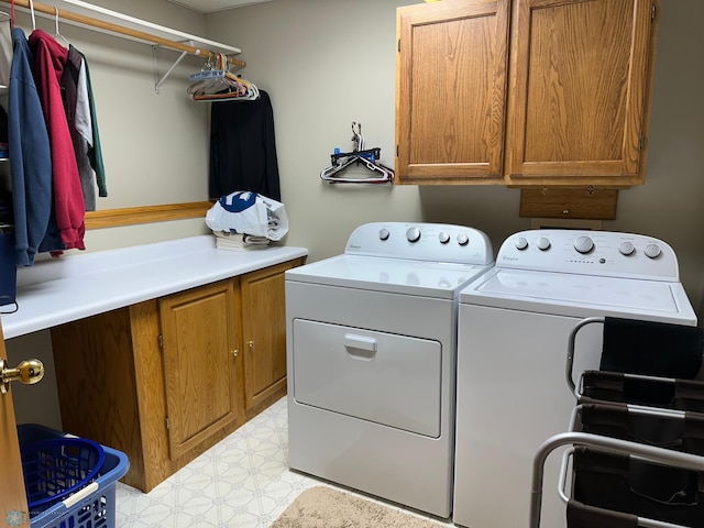 clothes washing area with light tile patterned floors, cabinets, and washer and dryer