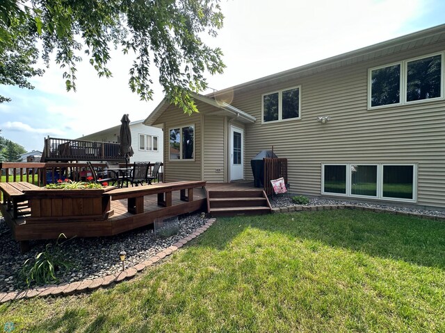 rear view of property featuring a wooden deck and a yard