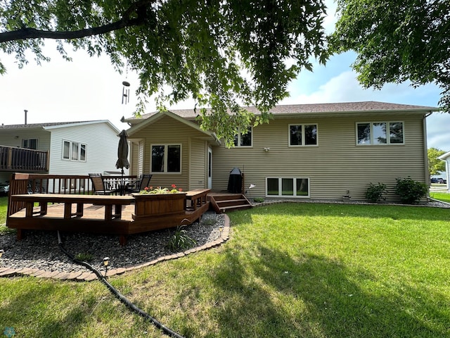 rear view of house with a wooden deck and a yard