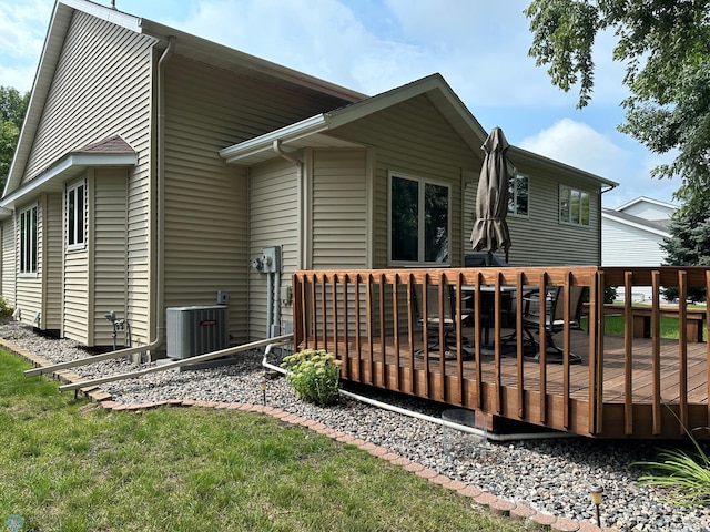 back of property with central AC unit and a deck