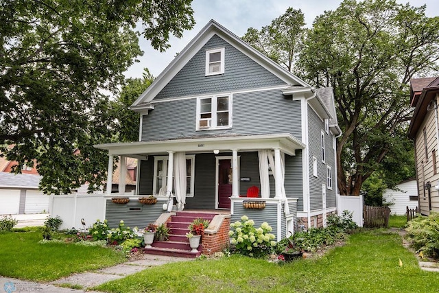 view of front of house featuring a garage, a porch, and a front yard