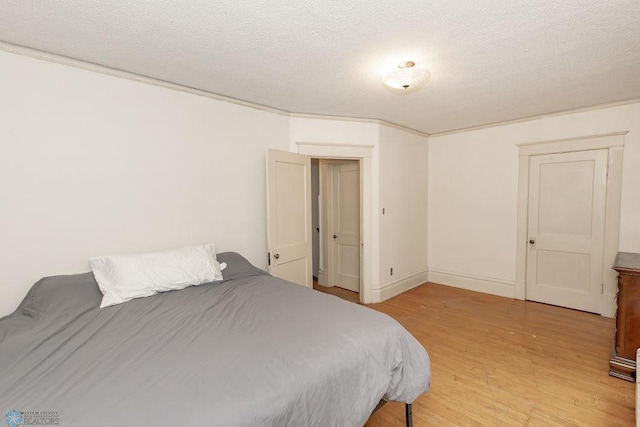 bedroom featuring a textured ceiling and light hardwood / wood-style floors