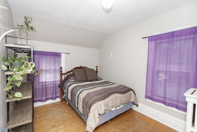 bedroom featuring vaulted ceiling and light hardwood / wood-style floors