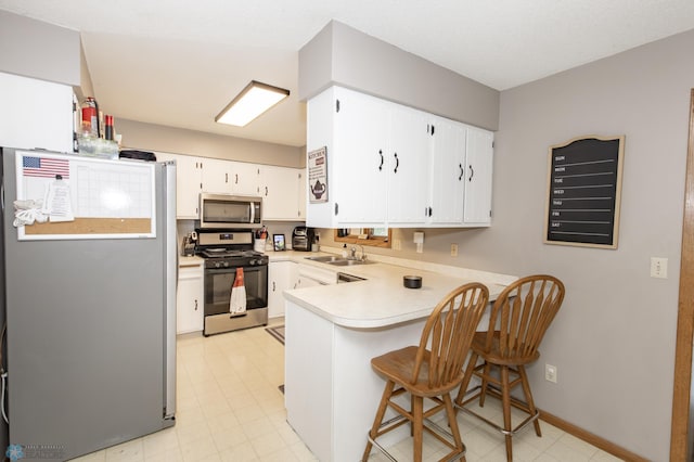 kitchen with white cabinetry, kitchen peninsula, light tile patterned floors, and stainless steel appliances